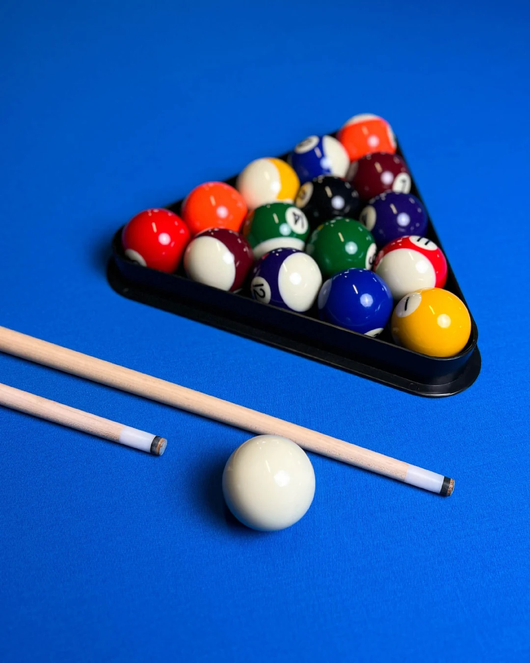 Billardkugeln und Queues auf dem blauen Billardtisch im Club